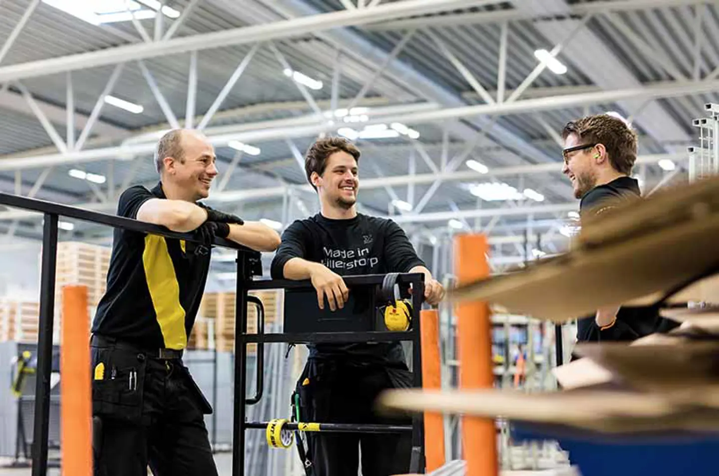 three men talking in warehouse environment